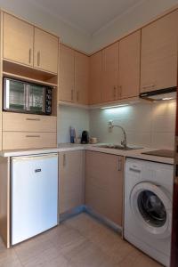 uma cozinha com uma máquina de lavar roupa e uma máquina de lavar roupa em Small Garden by Studio Spyros em Kanoni