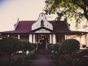 a large white building with a purple roof at De Avond Rust in Oudtshoorn