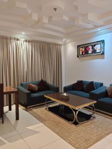 Sala de estar con 2 sofás azules y mesa de centro en Aldar Hotel, en Jazan
