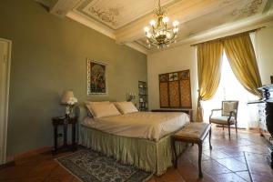 a bedroom with a bed and a chandelier at Villa Messori Spa in Castelvetro di Modena