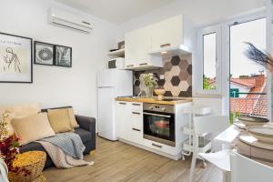 a kitchen and living room with a couch and a stove at Charming renovated apartment next to the sea in Šibenik