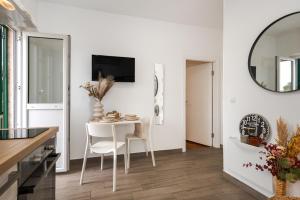 a kitchen with a white table and chairs and a mirror at Charming renovated apartment next to the sea in Šibenik