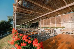 a restaurant with wooden tables and chairs and flowers at Camping Gardenia - Bungalow Deja View in Lozenets