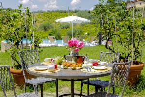 einen Tisch mit einem Teller Essen und Blumen darauf in der Unterkunft Fattoria la Luna 15 min da Firenze trilocale Archetti piscina e wi-fi in Lastra a Signa