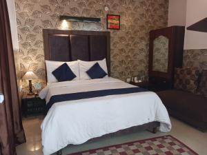 a bedroom with a large bed with blue and white pillows at Ceyone Hotels in Mussoorie