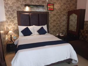 a bedroom with a large bed with blue and white pillows at Ceyone Hotels in Mussoorie