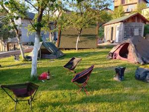 a yard with tents and chairs in the grass at Tent Camping in Sarajevo