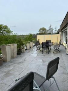 eine Terrasse mit Stühlen und Tischen auf der Terrasse in der Unterkunft TH 615 Panoramic Hohegeiß in Braunlage
