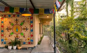 un edificio con parete colorata e sentiero di Eevolve Dharamkot - An Eco Hostel a McLeod Ganj