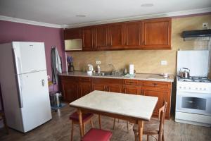 a kitchen with a table and a white refrigerator at Nadia & Minadora Central Retreat in Telavi