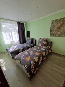 1 dormitorio con 2 camas y ventana en Olimp, en Daugavpils