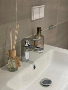 lavabo con dispensador de jabón en First Apartment Lillestrøm, en Lillestrøm