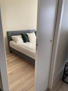 Cama en habitación con espejo en First Apartment Lillestrøm, en Lillestrøm