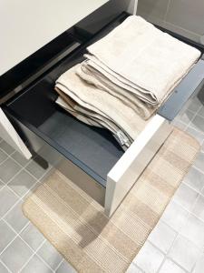 una pila de toallas plegadas sentadas en un estante en una cocina en First Apartment Lillestrøm, en Lillestrøm