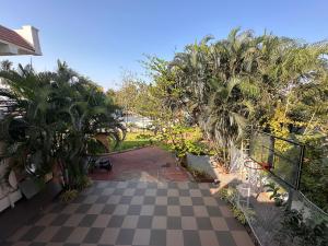 een uitzicht op een binnenplaats met een geruite vloer en palmbomen bij Room stay near HAMPI in Koppal