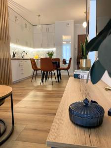 kuchnia i salon ze stołem i krzesłami w obiekcie Komfi Apartment w mieście Białystok