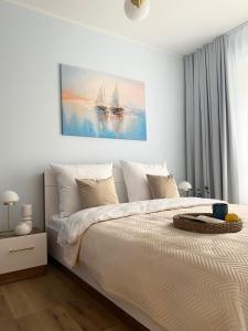 sypialnia z dużym łóżkiem i obrazem na ścianie w obiekcie Komfi Apartment w mieście Białystok