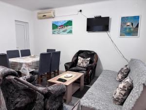a living room with a table and chairs and a tv at Apartments Matija in Sutomore