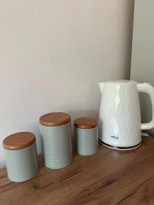 three cups and a pitcher on a wooden shelf at POKLEKANE in Wysowa-Zdrój