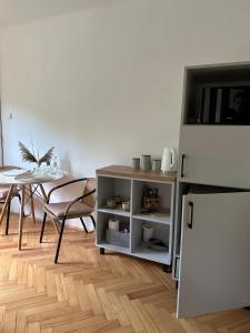 a living room with a table and a white refrigerator at POKLEKANE in Wysowa-Zdrój
