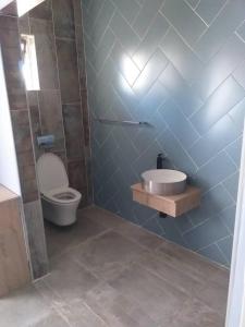 La salle de bains est pourvue de toilettes et d'un lavabo. dans l'établissement Beautiful No Fuss Serene 4-Bed House in Bulawayo, à Bulawayo