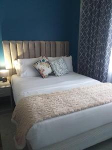- un lit avec 2 oreillers dans une chambre dans l'établissement Beautiful No Fuss Serene 4-Bed House in Bulawayo, à Bulawayo