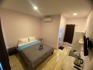 Un dormitorio con una cama con zapatos. en โรงแรมบ้านสวนวินเทจ en Ban Nam Mong