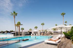 una piscina en un complejo con palmeras en La Isla y el Mar, Hotel Boutique, en Puerto del Carmen