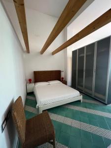 1 dormitorio con 1 cama y 1 silla en Sant'Andrea, en Capo dʼOrlando