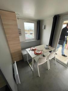 um pequeno quarto com uma mesa e cadeiras e uma janela em Nette 4-persoons chalet aan het Lauwersmeer em Lauwersoog