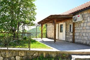 ein Steinhaus mit einem Tor und einem Zaun in der Unterkunft Martina in Cetinje