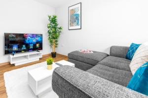 sala de estar con sofá gris y TV de pantalla plana en Two Bed Apartment - Two Parking Spaces - Stourbridge - Top Rated - Netflix - Wifi - 1BS, en Amblecote