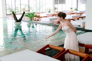 a woman in a white dress standing in a swimming pool at LuckyStar Hotel in Pleiku