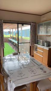 a kitchen with a table with a view of a yard at 然舎(ZENSYA)お茶場隣の一軒家。自然の中BBQもできます。高速、駅近いラッキー in Kakegawa
