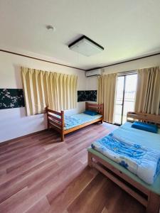 a bedroom with two beds and a window at 然舎(ZENSYA)お茶場隣の一軒家。自然の中BBQもできます。高速、駅近いラッキー in Kakegawa