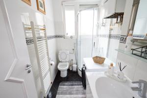 een witte badkamer met een toilet en een wastafel bij Old Town Elegance Sarajevo in Sarajevo +12 foto's