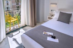 a hotel room with a bed and a balcony at SERHS Carlit Boutique Hotel in Barcelona
