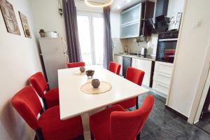 een keuken en eetkamer met een witte tafel en rode stoelen bij Old Town Elegance Sarajevo in Sarajevo