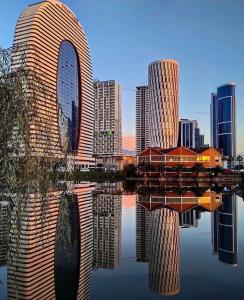 una vista di una città con riflessione nell'acqua di Batumi allince Palace a Batumi