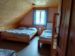 een slaapkamer met 2 bedden en een raam bij Chalupa Jadrná 2 in Orlické Záhoří 