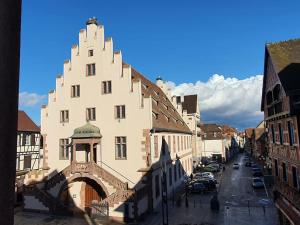 un grand bâtiment blanc avec une arche dans une ville dans l'établissement L'Arsenal - Appartement Centre ville - Poche commerces & restaurant - 6 P, à Sélestat