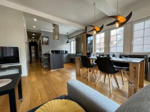 une cuisine et un salon avec une table et des chaises dans l'établissement L'Arsenal - Appartement Centre ville - Poche commerces & restaurant - 6 P, à Sélestat