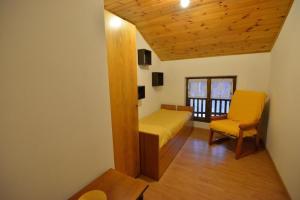 sypialnia z łóżkiem i krzesłem w pokoju w obiekcie Casa Faè Dolomiti w Madonna di Campiglio