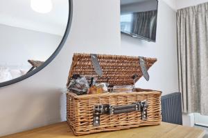 a wicker basket sitting on a table in front of a mirror at Ranfield's Brasserie Hotel Rooms in Coggeshall