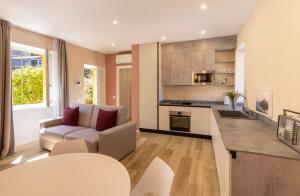 Il dispose d'une cuisine et d'un salon avec un canapé et une table. dans l'établissement Residence Casa Coppa Appartamento Jasmine, à Omegna