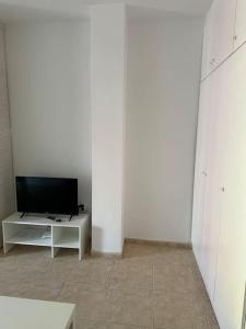 a white room with a television on a white table at Bonito Estudio en San Isidro bien situado in San Isidro