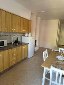 a kitchen with a table and a white refrigerator at Bonito Estudio en San Isidro bien situado in San Isidro