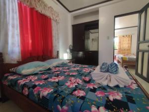 una camera da letto con un grande letto con fiori di Riverside at Aninuan Accommodation and Food a Puerto Galera