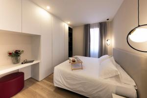 a hotel room with a white bed and a desk at Residence Casa Coppa Appartamento Jasmine in Omegna