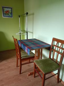a table and two chairs and a table and a lamp at Kornatka Hajnówka Pokoje Puszcza Białowieska in Hajnówka